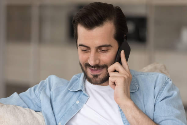 istock Head shot smiling young man involved in phone call conversation. 1402529847