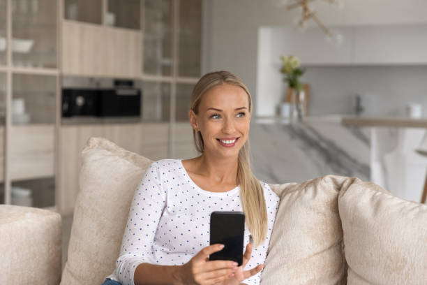 istock Dreamy beautiful young blonde woman using smartphone. 1402530734