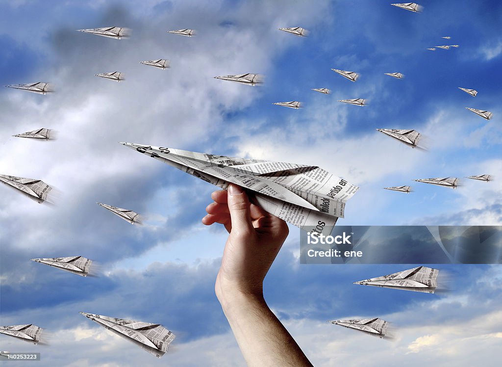 paper plane a hand throwing a paper plane to join others planes Newspaper Stock Photo