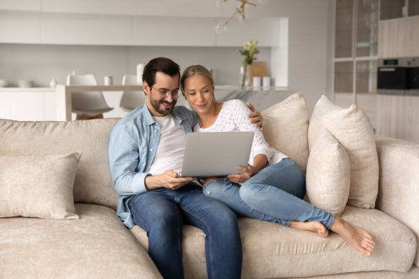 istock Happy loving young family couple using computer at home. 1402532306