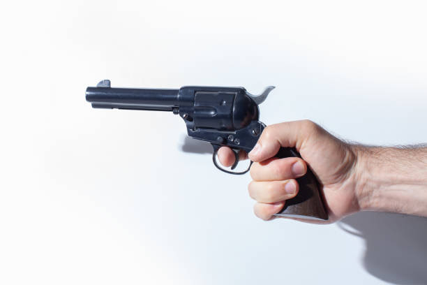 рука держит реплику пистолета, изолированную на белом фоне - color image cowboy plastic people стоковые фото и изображения