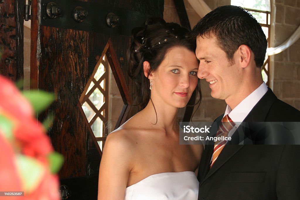 Couple Close A bride and groom standing in chapel doorway Adult Stock Photo