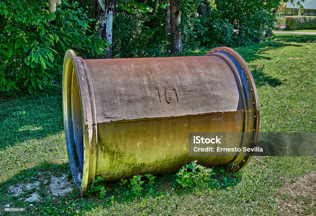 Large steel pipe used in the ancient conduction of water to the cities. Selective focus. Abandoned Stock Photo