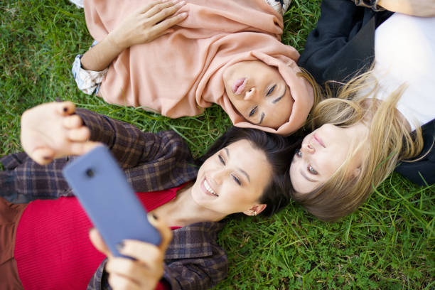 istock Multiracial girlfriends lying in circle and taking selfie 1402541058
