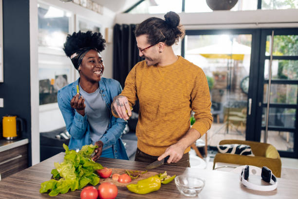 istock Young man and his Afro girlfriend preparing a vegetarian dinner at home 1402545615