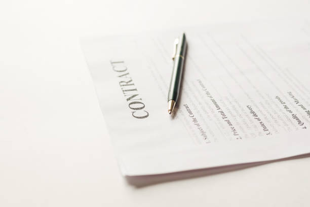 Fastened pages with legal documents and pen on white background.