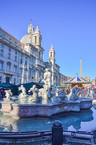 Moor Fountain and Christmas market Fontana del Moro (Moor Fountain) at the Piazza Navona and a Christmas market in Rome, Italy. It represents a Moor, or African, perhaps originally meant to be Neptune, standing in a shell, wrestling with a dolphin, surrounded by Tritons. fontana del moro stock pictures, royalty-free photos & images