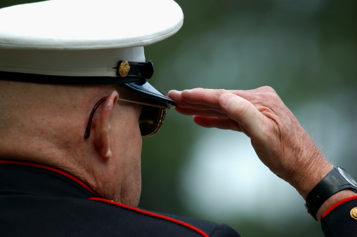 Close up of an elderly retored Marine saluting