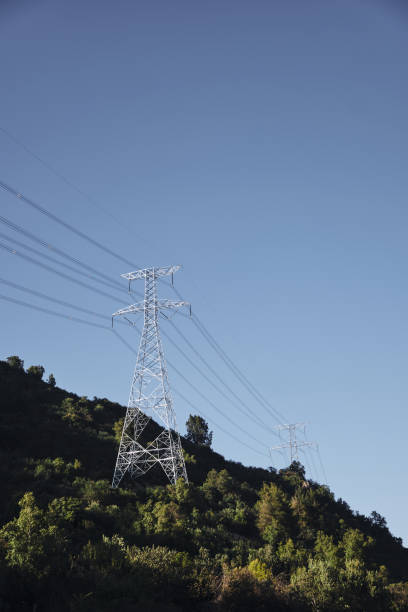 istock Electric power towers in the mountains blue sky background. 1402558049