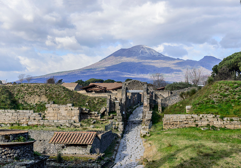 Clouds in the sky above the ancient roman ruines and the city gate Porta Nocera and mount Vesuvius in town of Pompeii, Italy.