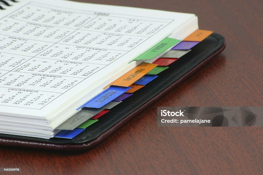 An organizer with colorful dividers lying on a desk personal organizer book open on a desk Address Book Stock Photo