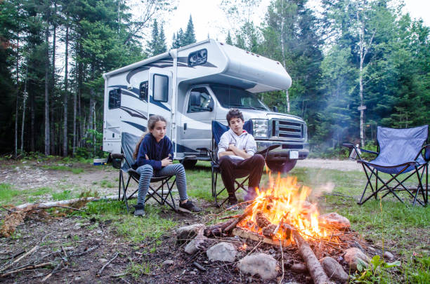 istock Girl and boy looking at campfire 1402560375
