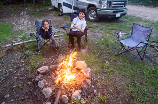 istock Girl and boy looking at campfire 1402560377