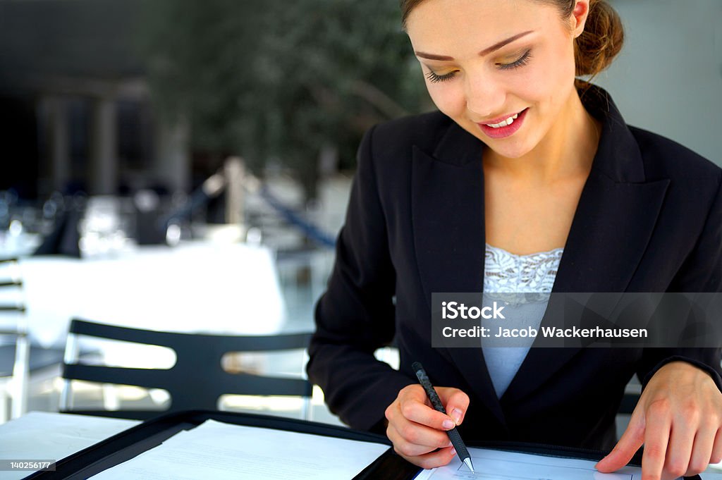 Femme d'affaires examinant les détails dans un café - Photo de 20-24 ans libre de droits
