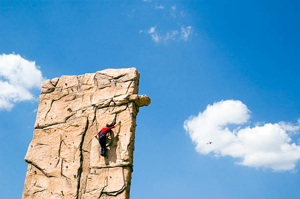 Young woman climb wall stock photo
