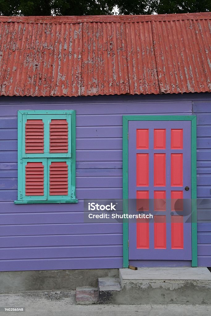 Bright Home in Barbados Bright purple home in Barbados with rusted pink roof and colorful window and door Barbados Stock Photo