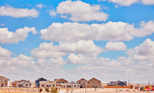 Newly constructed residential homes in Mid Western USA under bright blue sky with clouds