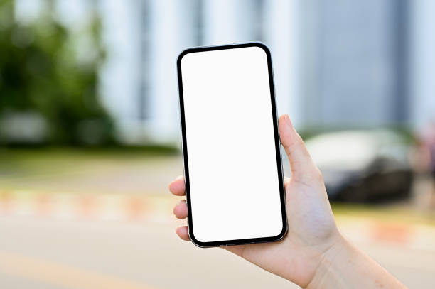 istock Close-up, A female hand holding a smartphone mobile phone white screen mockup 1402568671