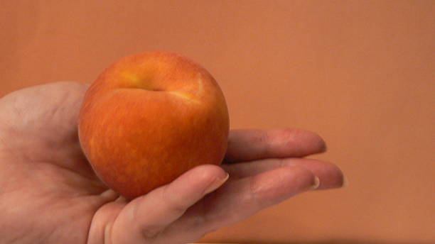 istock Peach in the palm of a womans hand 140257012