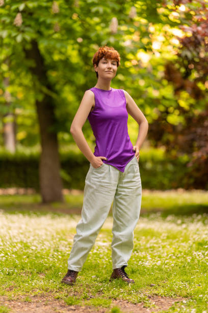 istock Confident lesbian woman on lawn in park 1402574890