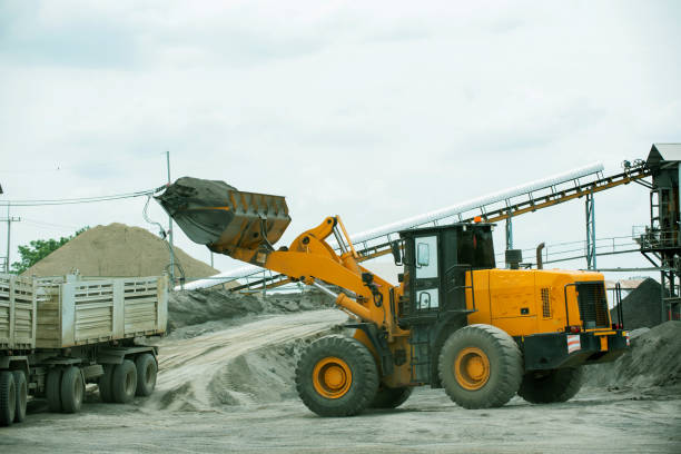 istock Sand loaders are shoveling rocks into dump trucks. 1402575040