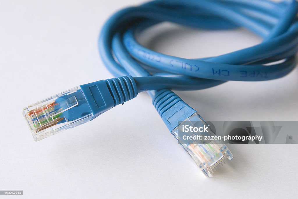 Netcable A blue CAT 5 network cable coiled against a white background. Cable Stock Photo