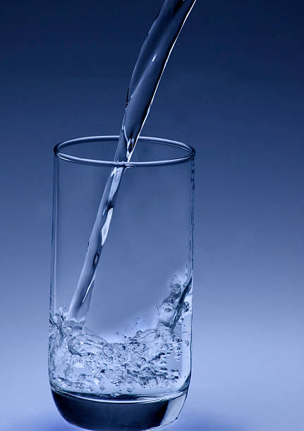 Close up of water pouring in a Glass stock photo