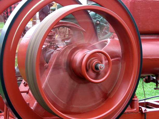 Red Drivewheel Red drivewheel on antique farm equipment, with motion blur. fly wheel stock pictures, royalty-free photos & images