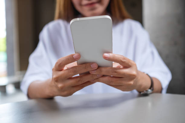 istock Closeup image of a young woman holding and using mobile phone 1402579080