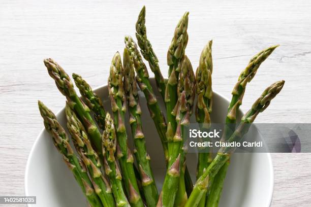 Fresh Asparagus In A Bowl Isolated On Wooden Background Stock Photo - Download Image Now
