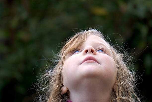 istock Young girl looking up toward sky 140258251