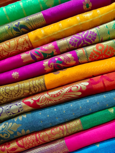 closeup view of stacked colours saris or sarees in display of indian retail shop, textile shop. - sari imagens e fotografias de stock