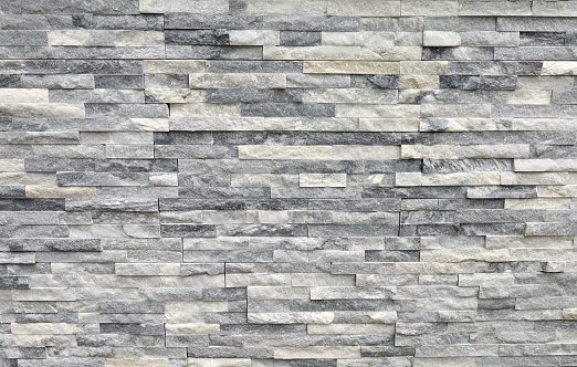 Pared de revestimiento de piedra hecha de ladrillos regulares de rocas blancas, grises y negras. Paneles para exterior. photo