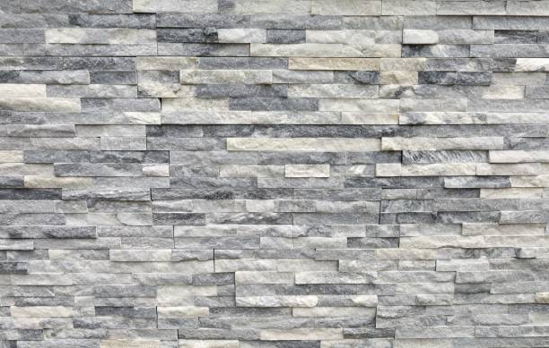 istock Stone cladding wall made of regular bricks of white, gray and black rocks. Panels for exterior. 1402587741