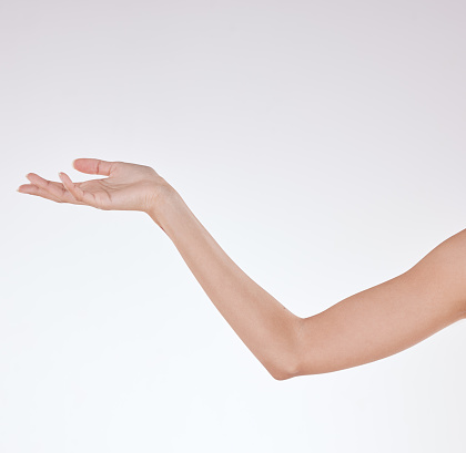 Closeup of unrecognizable mixed race with soft skin posing against a white copyspace background. Unknown Hispanic woman's hand reaching out after a beauty treatment