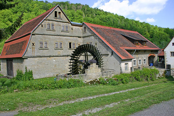 an old european farmhouse with a water wheel