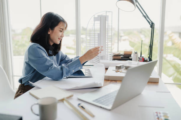 istock Selective focus, Asian female architect or engineer Currently considering materials for designing modern condominiums. Asian female architect or engineer Sit and analyze, design projects in the office 1402590059