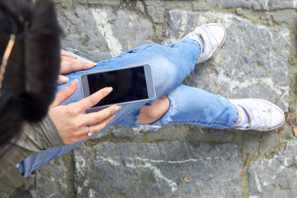 istock Woman in jeans using modern smartphone outdoors. 1402594116