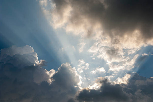 Sonnenstrahl Sunbeams of the obscured sun make their way through the cloud cover cumulonimbus stock pictures, royalty-free photos & images