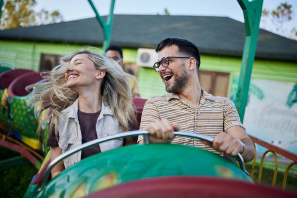 istock Young cheerful couple having fun on rollercoaster at amusement park. 1402596975