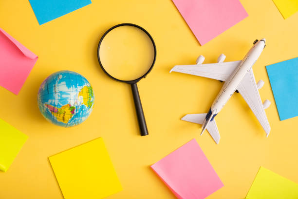 istock Travel flat lay composition of airplane with blank notes, globe and magnifier on yellow background. Trip prepare concept 1402597193