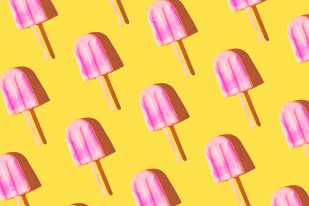 istock Trendy sunlight Summer pattern made with pink ice cream on bright light yellow background. Minimal summer concept 1402597514