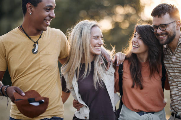 istock Young cheerful couples communicating while walking embraced in the park. 1402597548