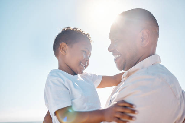 istock Smiling mixed race father carrying his small son on beach with copyspace. Adorable, happy, little, hispanic boy bonding with his single parent outside over a weekend. Man and child enjoying free time 1402598980