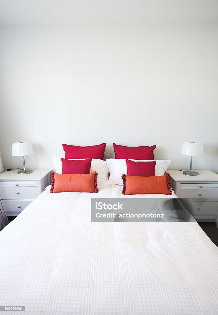 bedroom bed with sidetable and colorful pillows Bed - Furniture Stock Photo