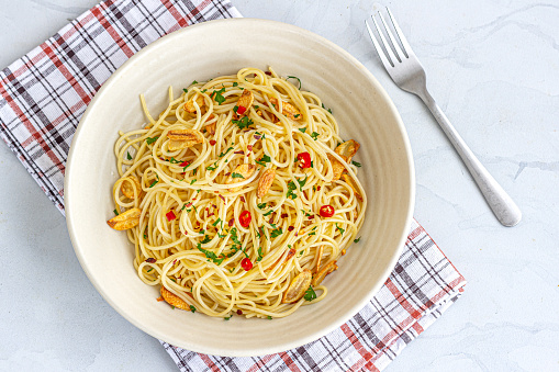 Spaghetti Aglio E Olio E Pepperoni in a Bowl with Fork Top Down Photo
