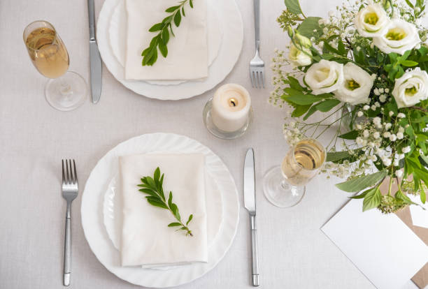 istock Wedding table decoration with white flowers, glasses and white napkins. Elegantly decorated table at a wedding reception. Festive table setting. The wedding decor. 1402600005