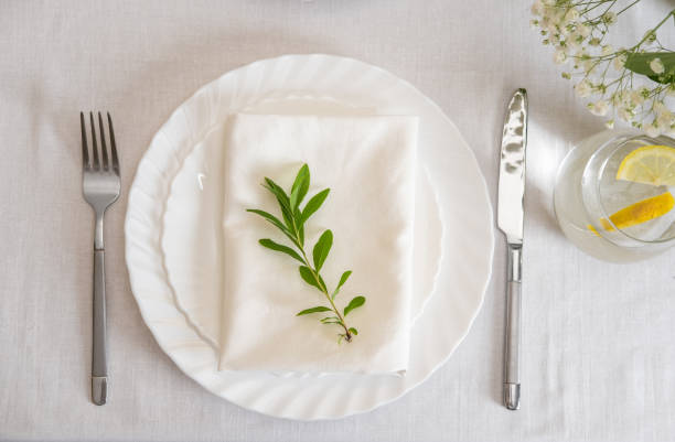 istock Wedding table decoration with white flowers, glasses and white napkins. Elegantly decorated table at a wedding reception. Festive table setting. The wedding decor. 1402600043