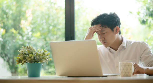 istock Young Asian man having stressful time working on laptop 1402601052