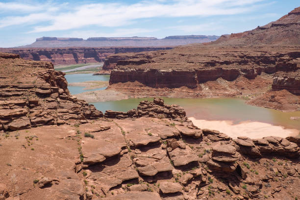 Colorado river winds through Utah desert on a very hot sunny day. Red rocks and sand in a dry country. River canyon in the desert. Geology of American west. Driving across the USA. stock photo
